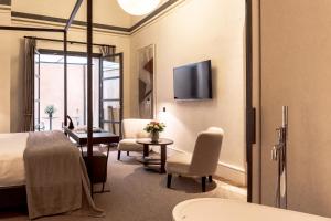 a hotel room with a bed and a table and chairs at Sant Francesc Hotel Singular in Palma de Mallorca