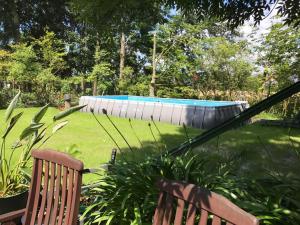 a swimming pool in a yard with two chairs at Nordsee-Paradies in Barlt