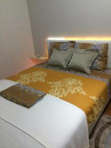 a bedroom with a bed with a gold and white comforter at Apartman Fenix in Belgrade