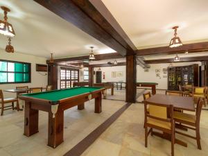 a pool table in a room with tables and chairs at Hotel Saveiros in Ubatuba