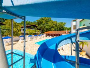 uma vista para a piscina a partir dos escorregas no resort em Hotel Saveiros em Ubatuba