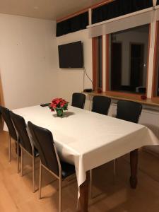 einen Tisch mit Stühlen und eine Vase mit Blumen darauf in der Unterkunft Sæból/Ocean Lair 2 in Grundarfjörður