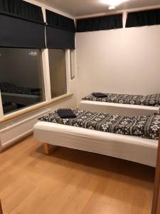 two beds in a room with a window at Sæból/Ocean Lair 2 in Grundarfjordur