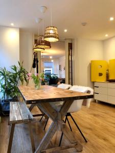 een eetkamer met een houten tafel en een keuken bij Bee Amsterdam - central apartment in the trendy Jordaan in Amsterdam
