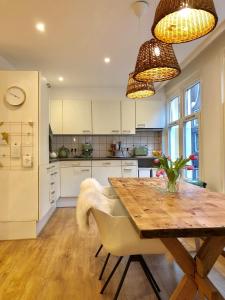 a kitchen with a wooden table and white cabinets at Bee Amsterdam - central apartment in the trendy Jordaan in Amsterdam