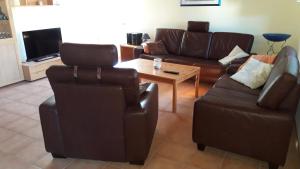 sala de estar con 2 sillas, sofá y mesa en Ferienwohnung Hück, en Lind