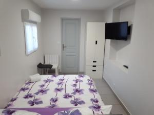 a bedroom with a bed with purple flowers on it at studio climatisé in Avignon