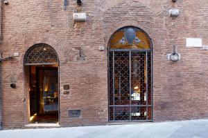 a brick building with two windows and a door at Palazzetto Rosso - Art Hotel in Siena