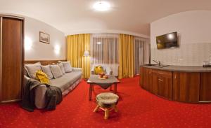 une chambre d'hôtel avec un canapé et une table dans l'établissement Willa Trela, à Muszyna