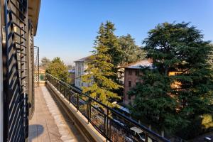 einen Balkon mit Blick auf Bäume und Gebäude in der Unterkunft Appartamenti Tommasini in Bologna