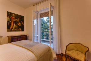 ein Schlafzimmer mit einem Bett und einem großen Fenster in der Unterkunft Appartamenti Tommasini in Bologna