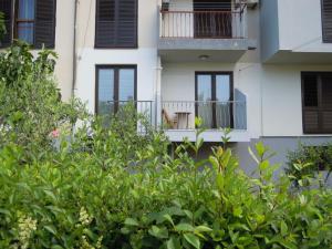 un edificio de apartamentos con balcón y árboles en Apartments Legend, en Rovinj