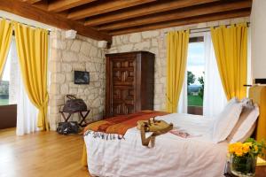 una camera da letto con un grande letto con tende gialle di Delser Verona Manor House a Verona