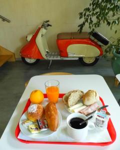 a tray with a plate of breakfast food and a scooter at Hotel Gameiro in Entroncamento