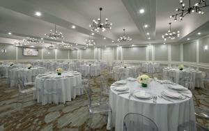 een feestzaal met witte tafels en stoelen en kroonluchters bij The Novotel Toronto Centre in Toronto