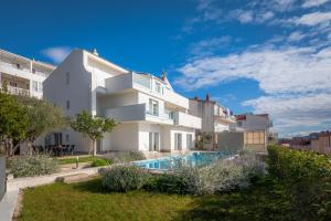 a white house with a swimming pool in front of it at Villa Elena in Podstrana
