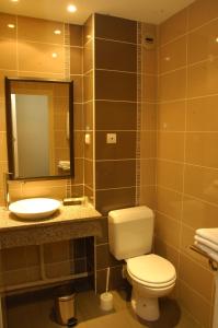 a bathroom with a toilet and a sink and a mirror at Logis Hôtel Restaurant Chez Nous in Sainte-Croix