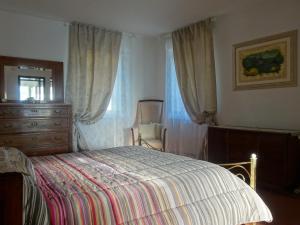 a bedroom with a bed and a dresser and a chair at Antico Uliveto in Seravezza