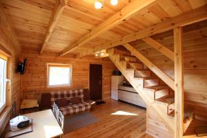 a log cabin with a staircase in a living room at Domek letniskowy Orzechowa in Giżycko