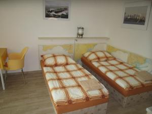 um quarto com 2 camas e uma cadeira amarela em Penzion Letná em Velké Mezirici