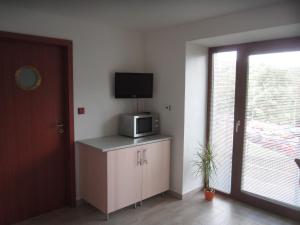 a living room with a microwave and a window at Penzion Letná in Velké Meziříčí