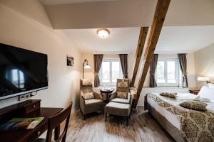 ein Hotelzimmer mit einem Bett und einem TV in der Unterkunft HOTEL DÜNENLÄUFER Langeoog in Langeoog