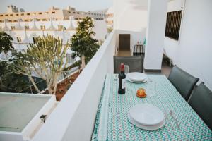 a table with a bottle of wine on a balcony at Home Nina in Playa de las Americas