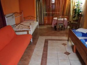 テルキバーニャにあるTóth Apartmanのベッド2台、ソファ、テーブルが備わる客室です。