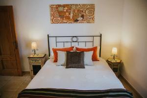 a bedroom with a bed with orange and white pillows at Home Maria in Playa de las Americas