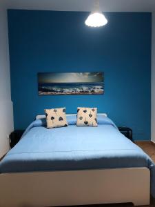 a blue bedroom with a bed with two pillows at IL GIARDINO DI NONNO AGOSTINO in Castellammare di Stabia