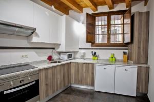 uma cozinha com electrodomésticos brancos e armários de madeira em Dúplex en la Judería de Toledo em Toledo