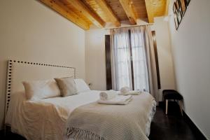 a bedroom with a bed with towels on it at Dúplex en la Judería de Toledo in Toledo