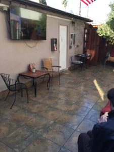 a patio with a table and chairs and a tv on the wall at Timen house in North Hollywood