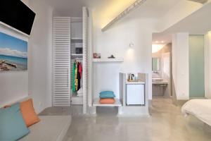 a white room with a bed and a bathroom at Kouros Village Hotel - Adults Only in Perissa