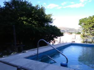 a swimming pool with a hose in the water at La Casa de Ramatis in Valle Hermoso