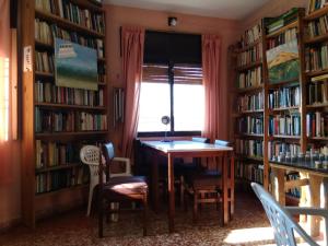 a library with a table and chairs and bookshelves at La Casa de Ramatis Posada in Valle Hermoso