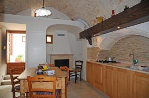 eine Küche mit einem Tisch und einem Esszimmer in der Unterkunft Casa del Carbonaio in Locorotondo
