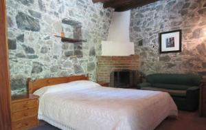 1 dormitorio con cama y pared de piedra en Ayios Andronikos Agrotourism House, en Kalopanayiotis