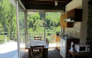 a kitchen with a table and a kitchen with a balcony at Ayios Andronikos Agrotourism House in Kalopanayiotis