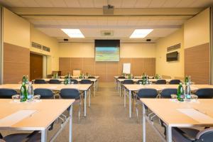 a classroom with tables and chairs and a projection screen at Hotel Kaskáda in Kuřim +51 photos
