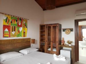 a bedroom with two beds and a book shelf at Pousada João Sol in Praia do Forte