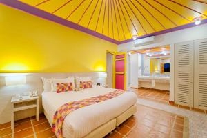 a bedroom with a large bed with a yellow ceiling at Hotel Mocawa Resort in La Tebaida