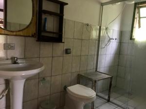 uma casa de banho com um WC, um lavatório e um chuveiro em Chalé do Félix em Ubatuba