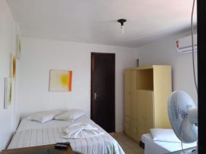 a room with two beds and a closet with a fan at Hotel Oldoni in Erechim