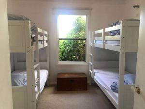 a room with two bunk beds and a window at Griffith St Beach House in Port Fairy