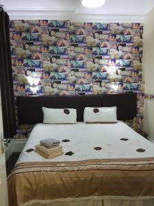 een bed in een kamer met een muur van foto's bij Portsmouth Budget Hotels - All rooms are EN-SUITE in Portsmouth