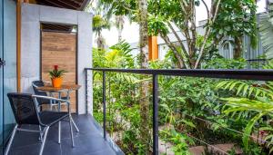 a patio with a table and a chair on a balcony at Pousada Armação de Camburi in Camburi +141 photos