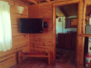 a tv in the corner of a log cabin at Cabaña Rincón de Manzano in Villa La Angostura