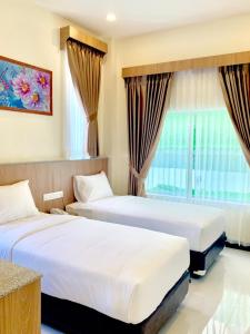 um quarto de hotel com duas camas e uma janela em Bintan Lumba Lumba Inn Hotel em Tanjung Pinang