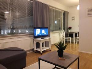 ein Wohnzimmer mit einem Flachbild-TV auf einem Tisch in der Unterkunft Hamina Orange Apartments Kadetti 1 in Hamina